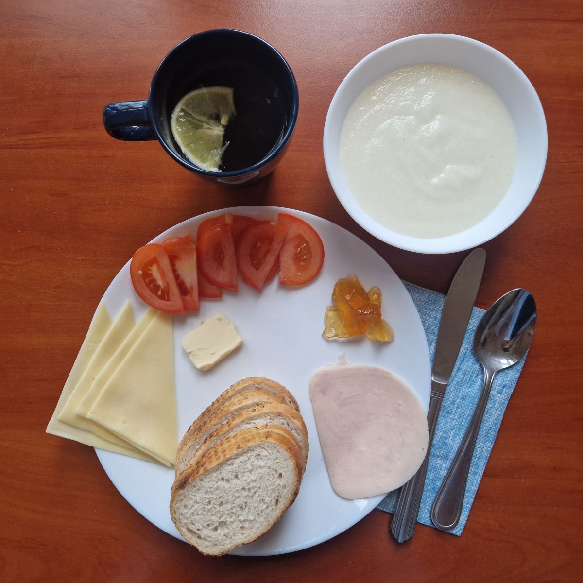 kasza manna, dżem, kanapki z wędliną, serem i pomidorem, herbata z cytryną