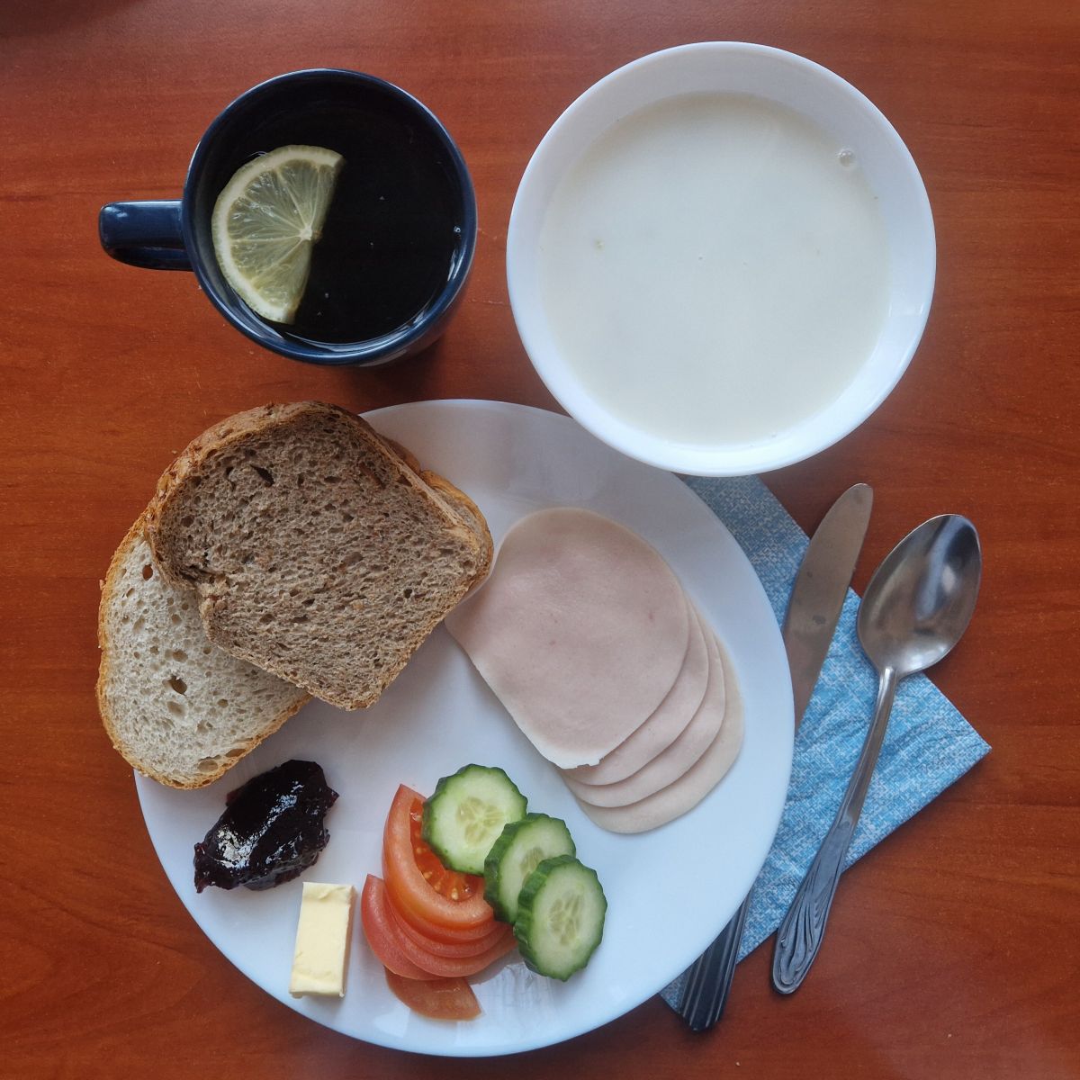 owsianka, dżem, kanapki z wędliną i warzywami, herbata z cytryną