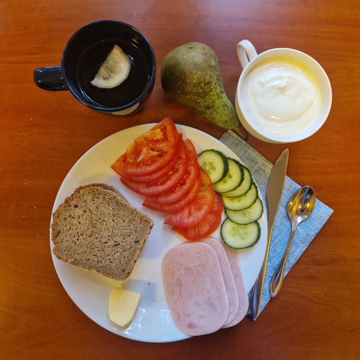 kanapki z wędliną i warzywami, herbata z cytryną, gruszka i jogurt