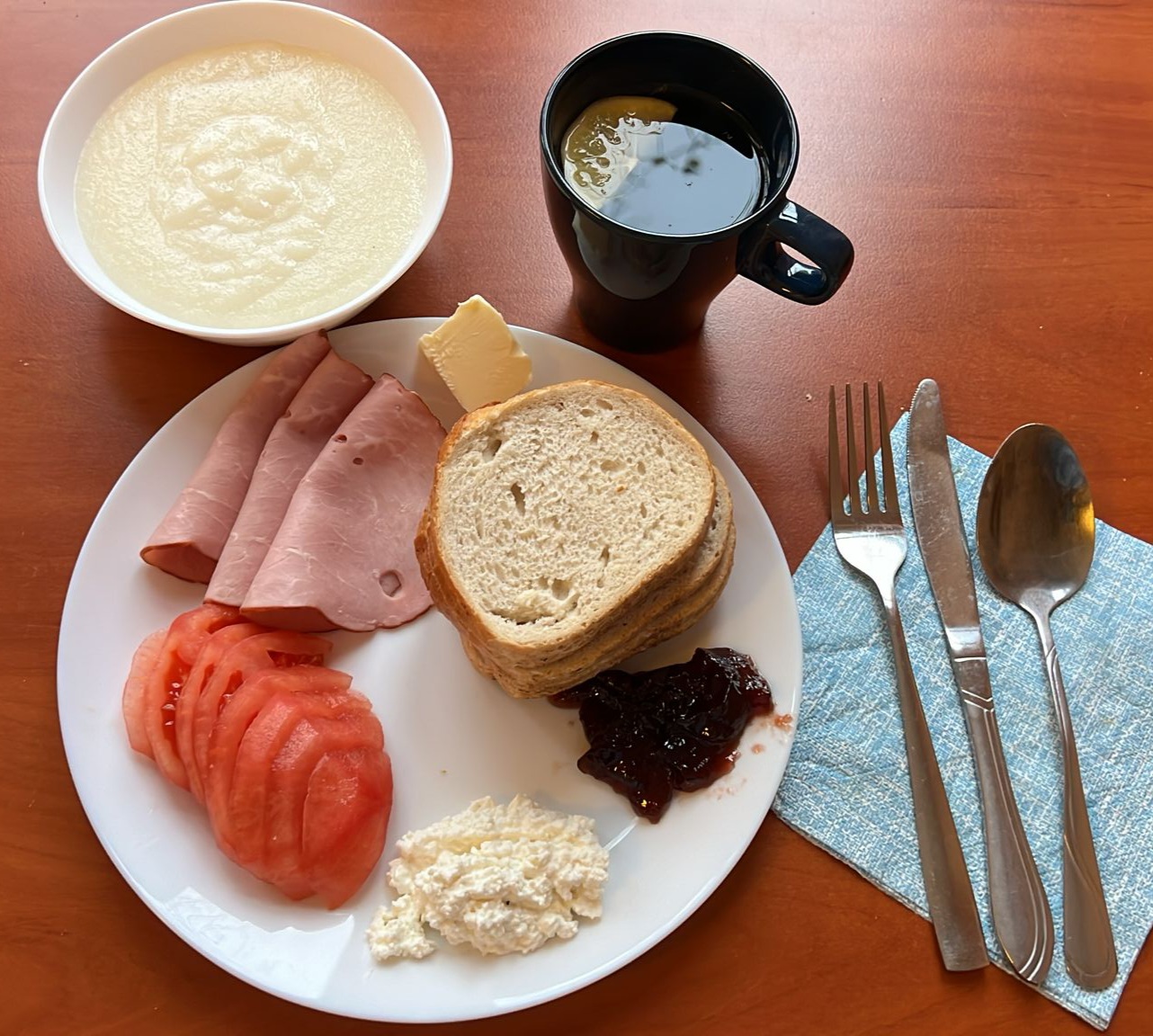 kasza manna, dżem, kanapki z wędliną i twarogiem, pomidor, herbata z cytryną