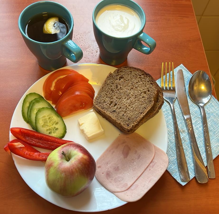 kanapki z wędliną i warzywami, herbata z cytryną, jogurt i jabłko