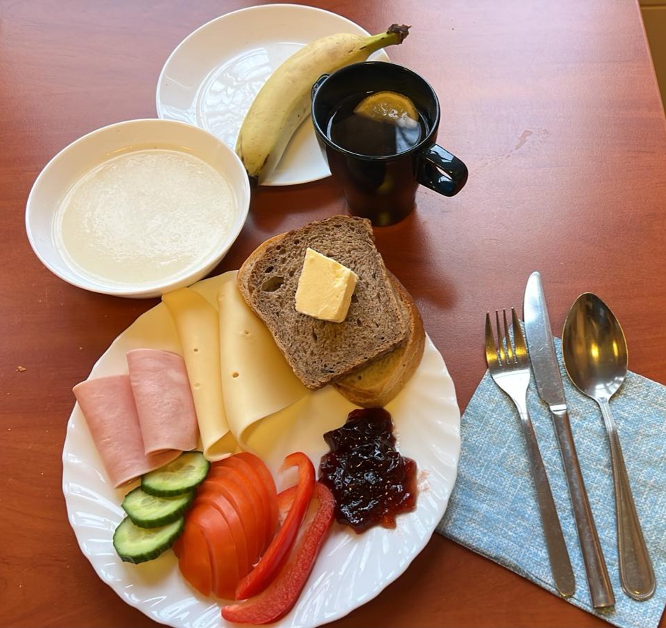 manna na mleku, dżem, kanapki z wędliną, serem i warzywami, herbata z cytryną, banan