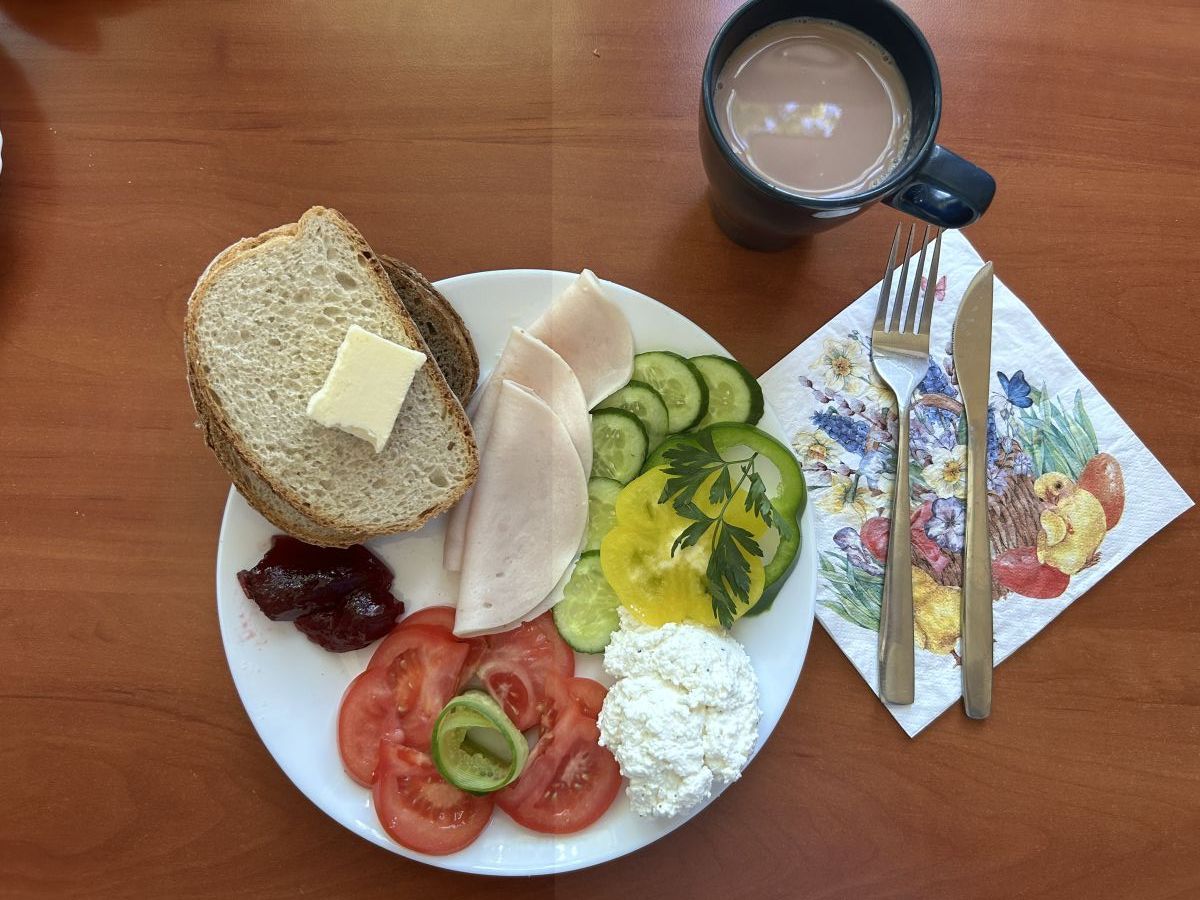 Chleb pszenny i żytni, pomidor, ogórek, twarożek, wędlina, dżem, kakao