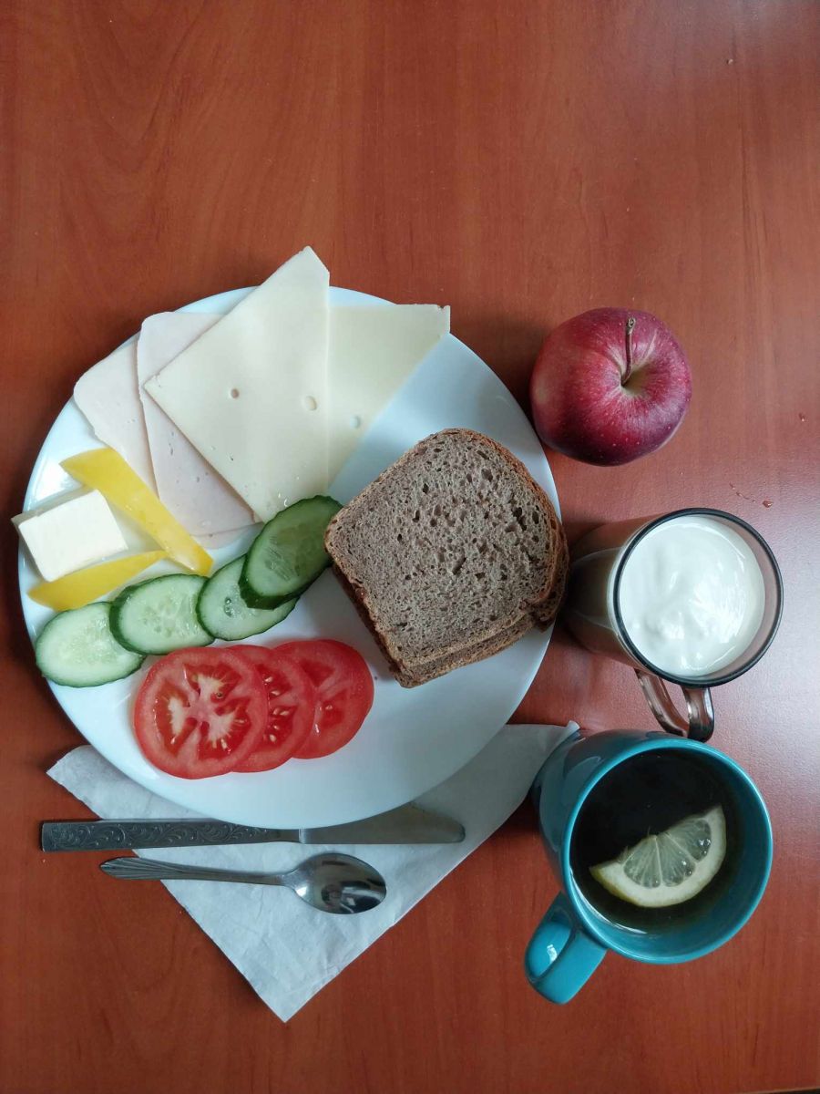 kanapki z serem, wędliną i warzywami, herbata z cytryną, jogurt i jabłko